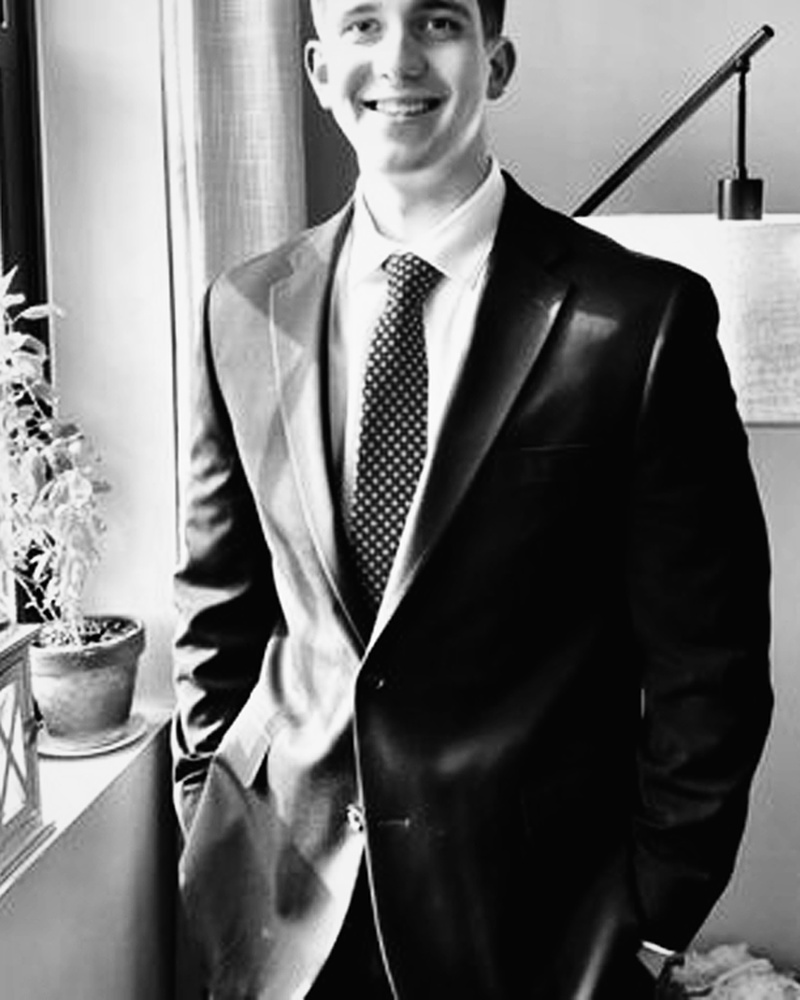 Black-and-white suit portrait for formalwear and specialty care content.
